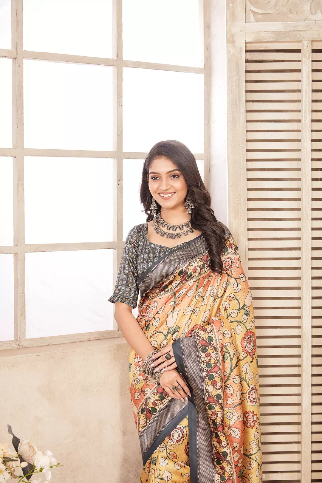 woman standing in Pastel Yellow Kalamkari diya saree.