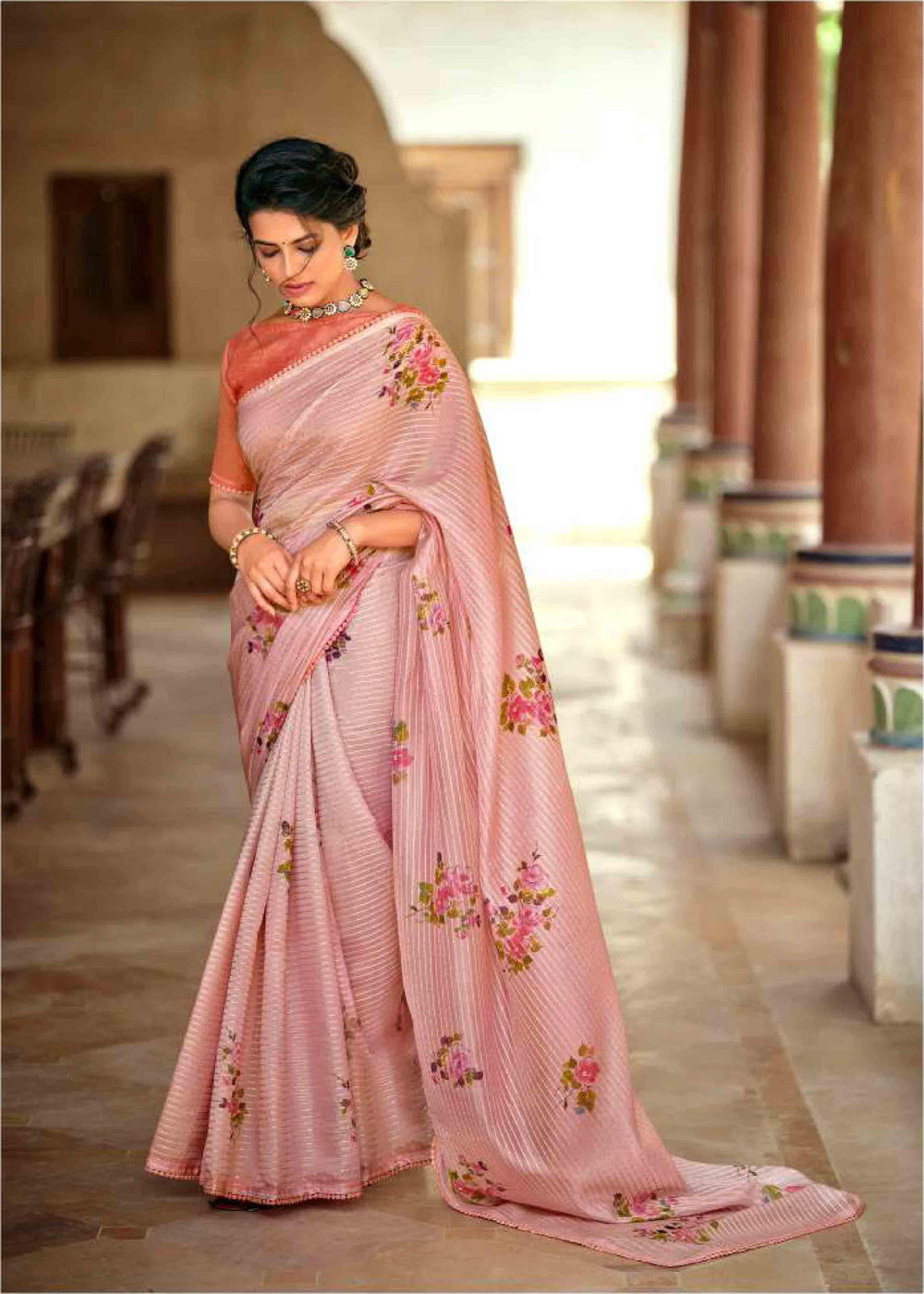 woman standing and looking down in floral crochet saree.