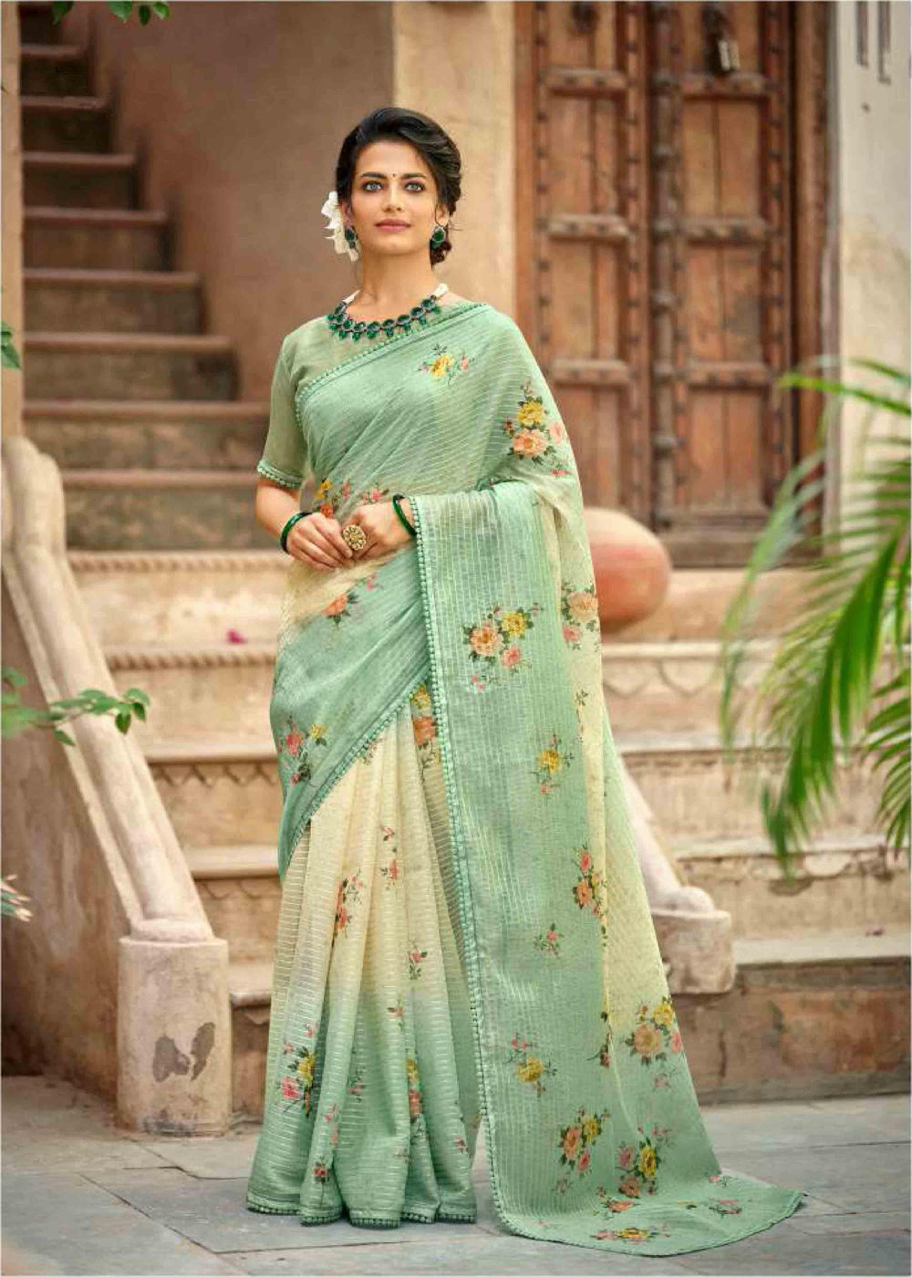 woman standing near steps in yellow green gradient floral crochet saree.