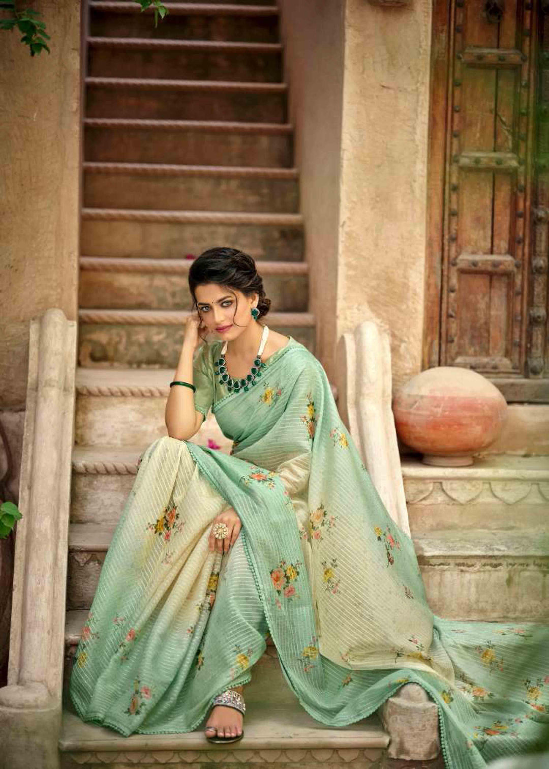 woman sitting on steps in yellow green gradient floral crochet saree.