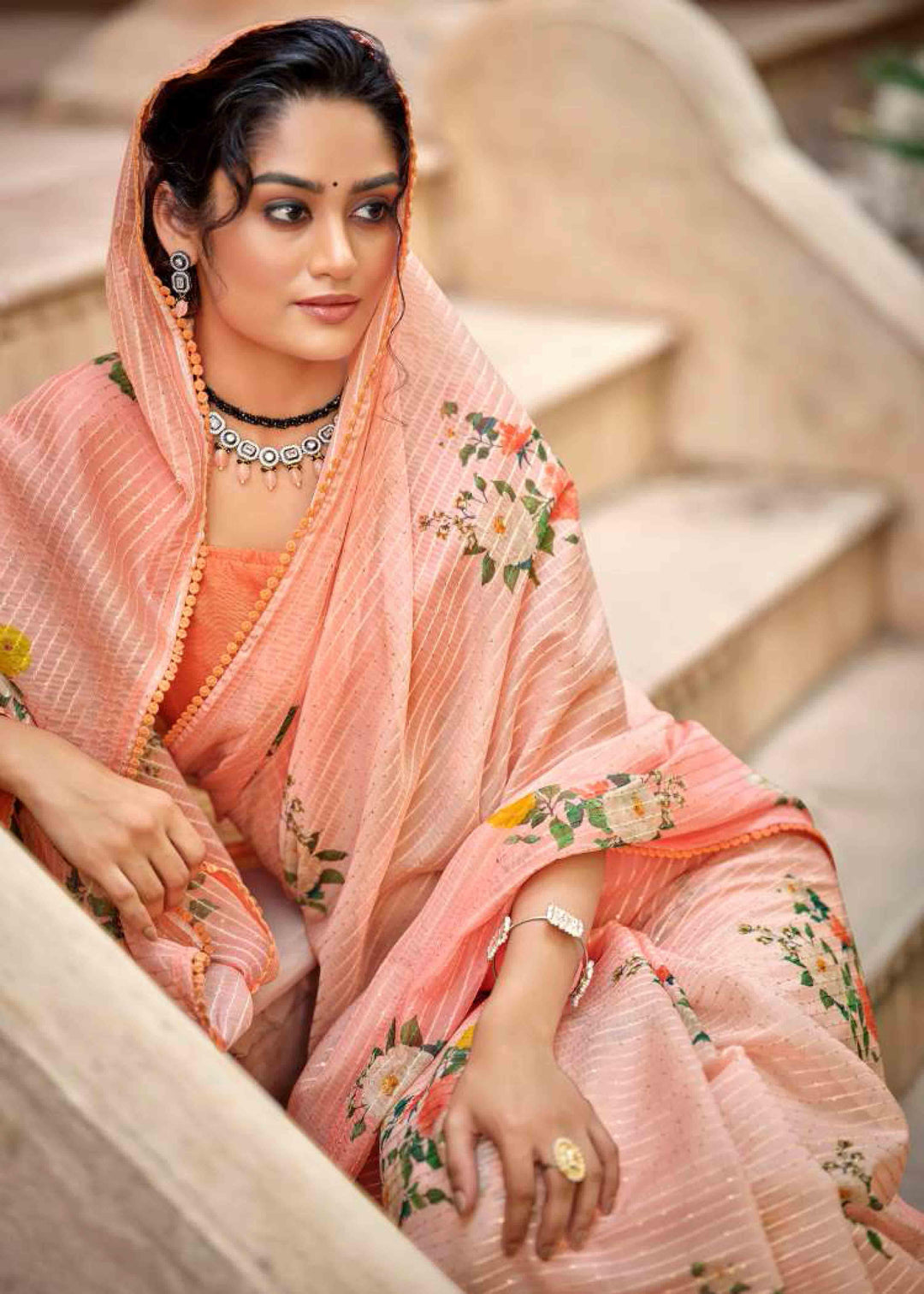 woman sitting on steps in floral crochet saree.